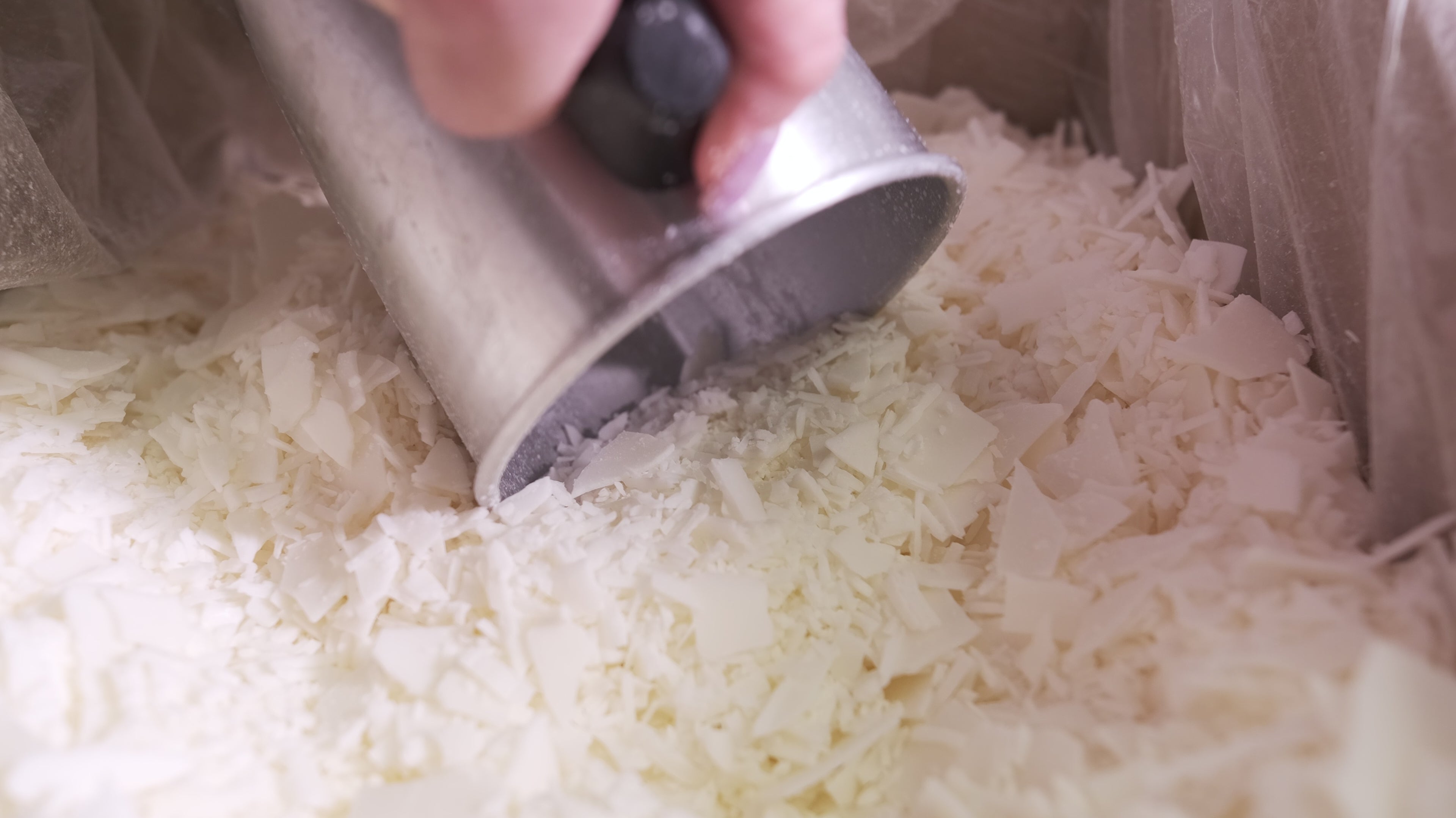 Load video: Shredded soy wax slowly being scooped up